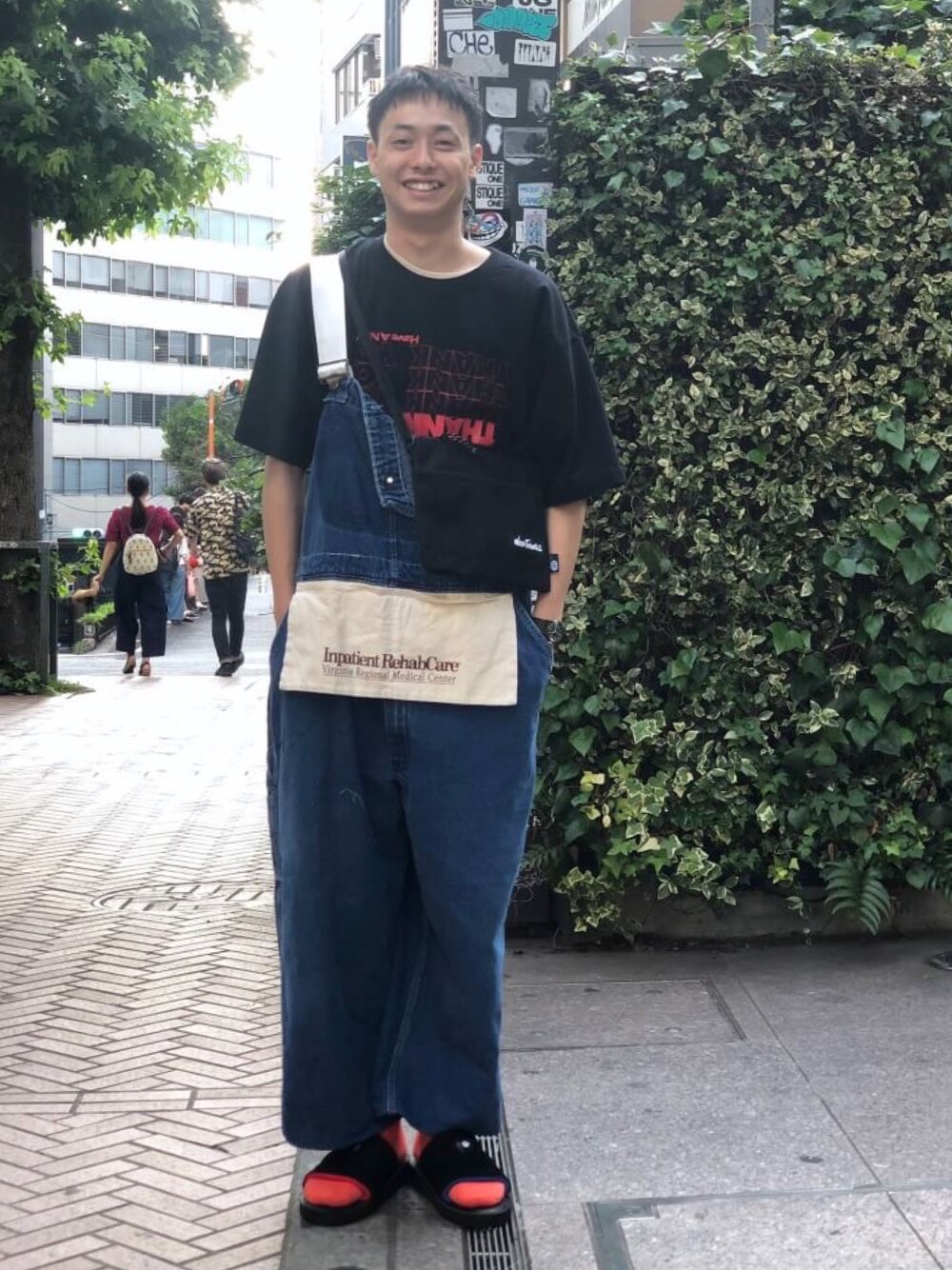 ホワイト系のショルダーバッグ、ブラック系のサンダルを着用したメンズの夏コーディネートの1枚目の写真