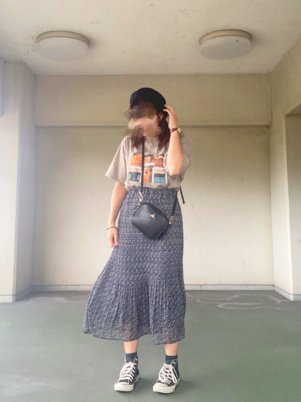 グリーン系のTシャツ/カットソー、ブルー系のスカート、ブラック系のスニーカーを着用したレディースの秋コーディネートの1枚目の写真