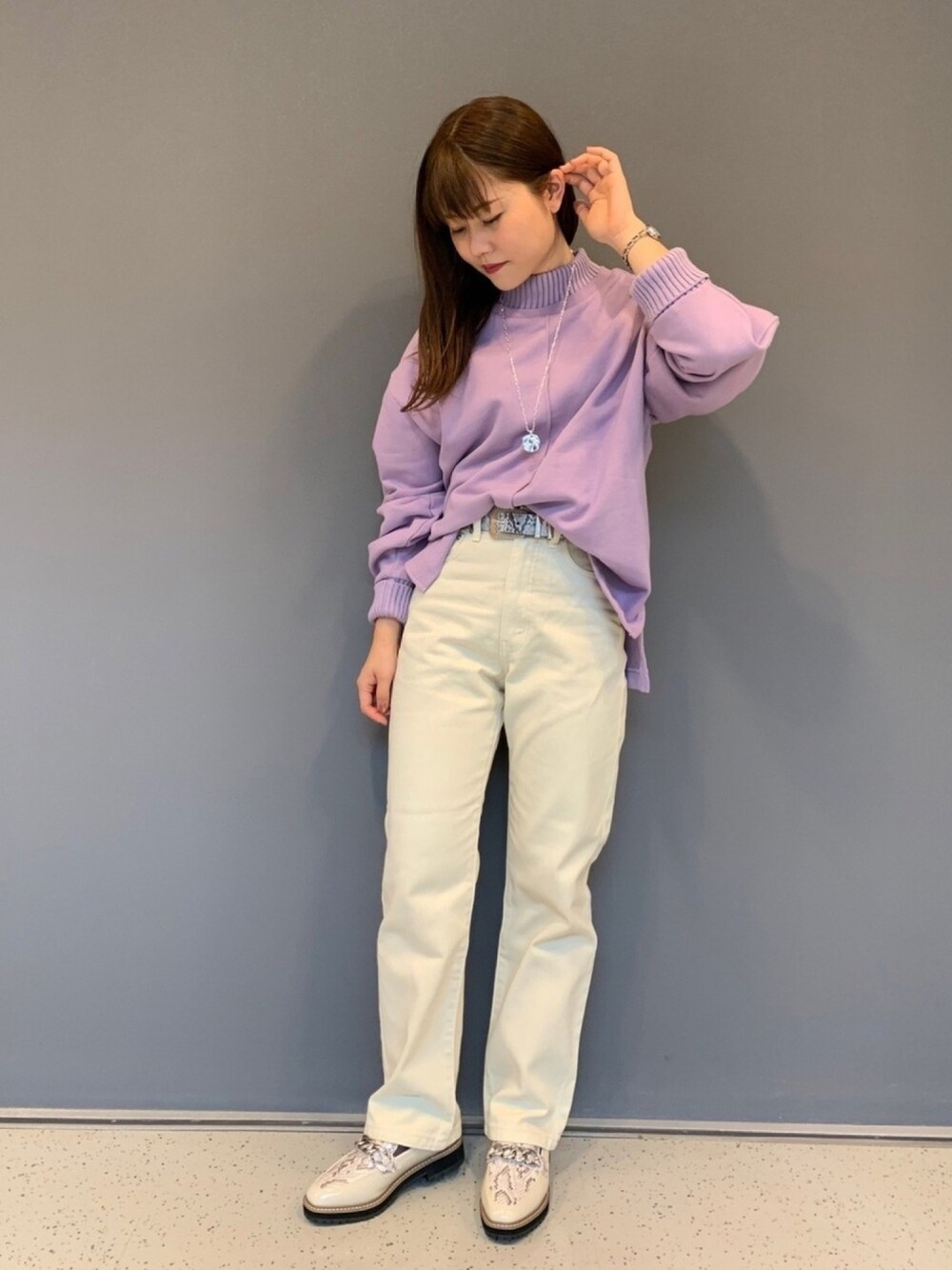 パープル系のスウェット、ホワイト系のデニムパンツ、ホワイト系のローファーを着用したレディースの秋コーディネートの1枚目の写真