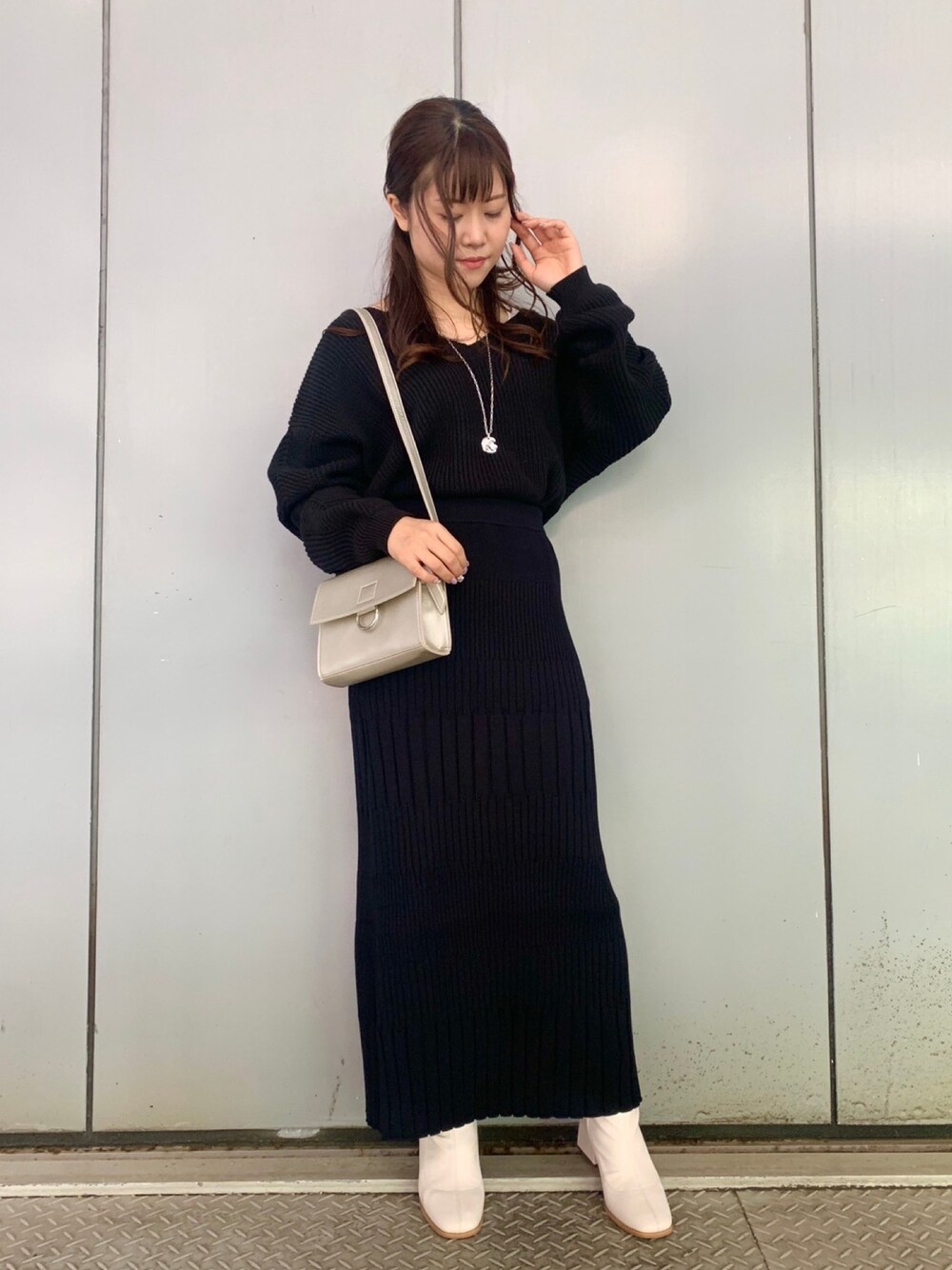 ブラック系のニット/セーター、ブラック系のスカート、その他のショルダーバッグを着用したレディースの秋コーディネートの1枚目の写真