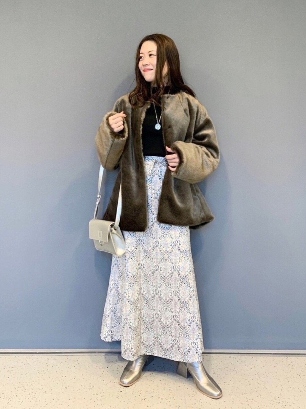 ブラウン系のジャケット/アウター、ブラック系のニット/セーター、ホワイト系のスカートを着用したレディースの秋コーディネートの1枚目の写真