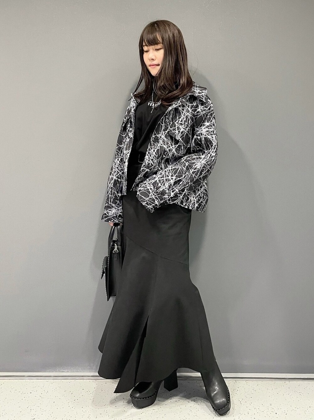 ブラック系のジャケット/アウター、ブラック系のTシャツ/カットソー、ブラック系のスカートを着用したレディースの冬コーディネートの1枚目の写真