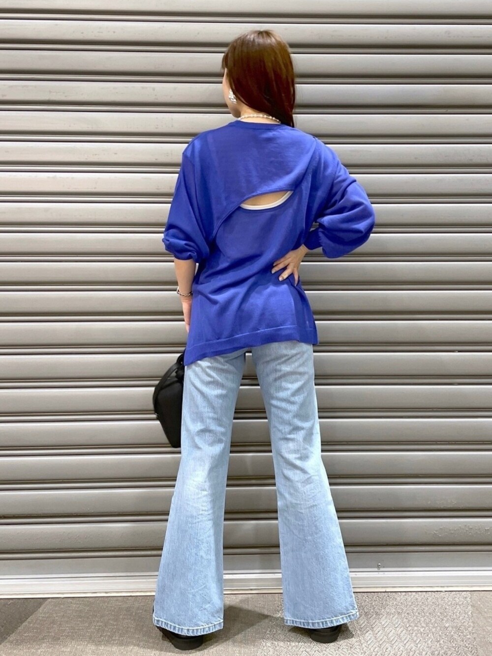 ブルー系のニット/セーター、ホワイト系のタンクトップ、ブルー系のデニムパンツを着用したレディースの春コーディネートの1枚目の写真