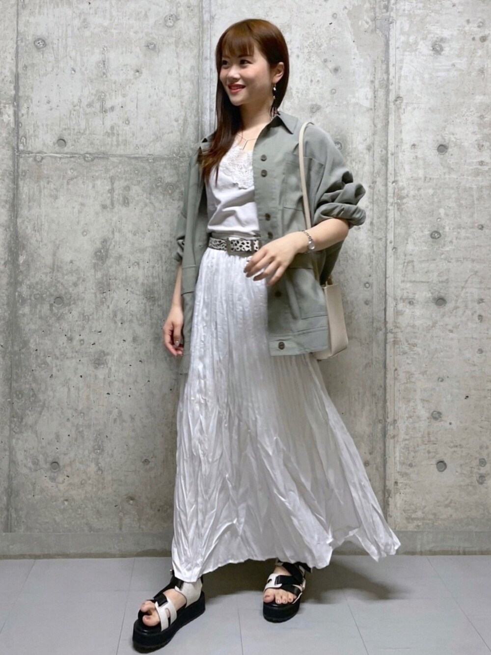 ベージュ系のショルダーバッグ、グリーン系のブルゾン、ベージュ系のTシャツ/カットソーを着用したレディースの夏コーディネートの1枚目の写真