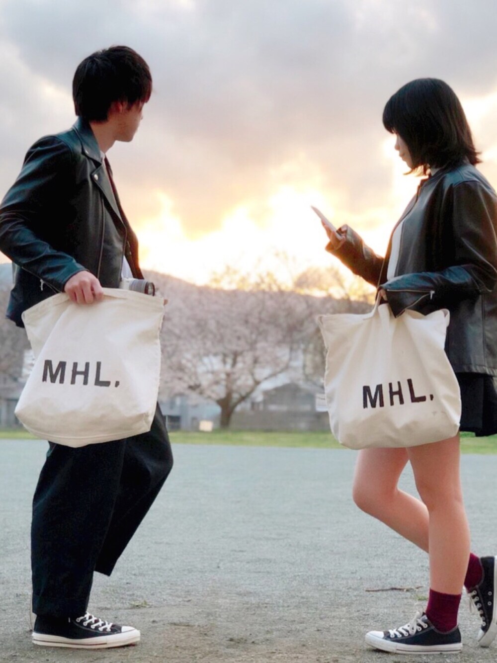 ブラック系のライダースジャケット、ホワイト系のショルダーバッグ、ブラック系のスラックスを着用したメンズの春コーディネートの1枚目の写真