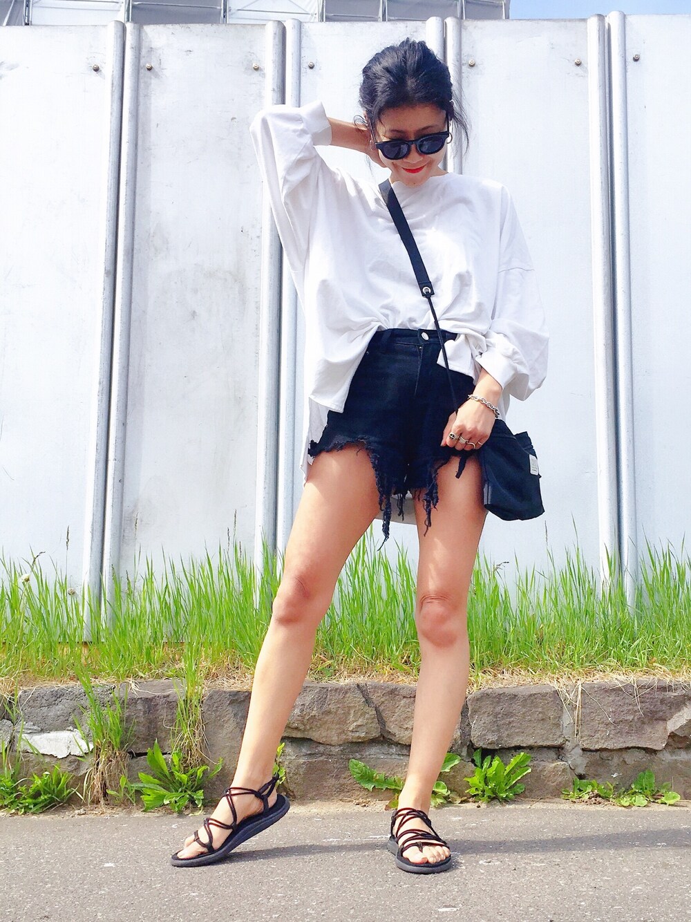 ホワイト系のスウェット、ブラック系のデニムパンツ、ブラック系のショルダーバッグを着用したレディースの春コーディネートの1枚目の写真