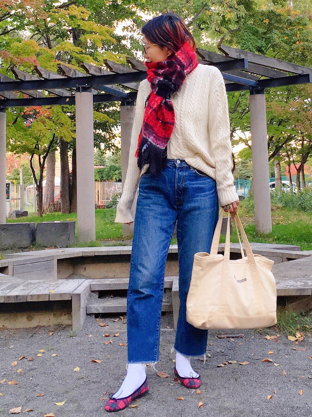 ホワイト系のニット/セーター、ブルー系のデニムパンツ、ホワイト系のバッグを着用したレディースの秋コーディネートの1枚目の写真