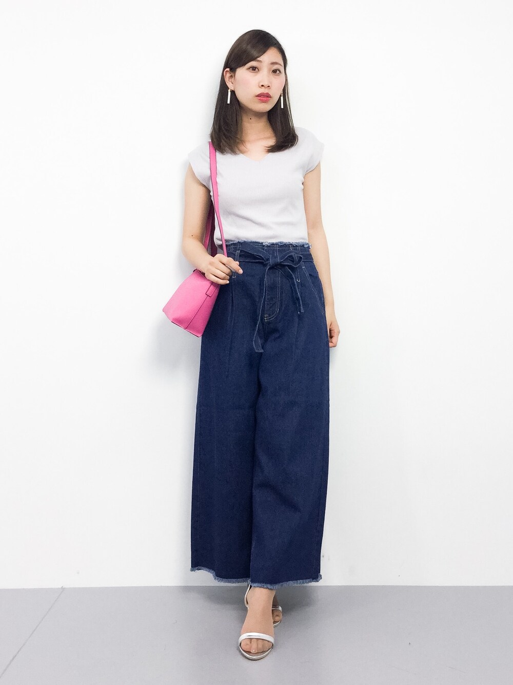 グレー系のTシャツ/カットソー、ブルー系のデニムパンツ、ピンク系のショルダーバッグを着用したレディースの春コーディネートの1枚目の写真