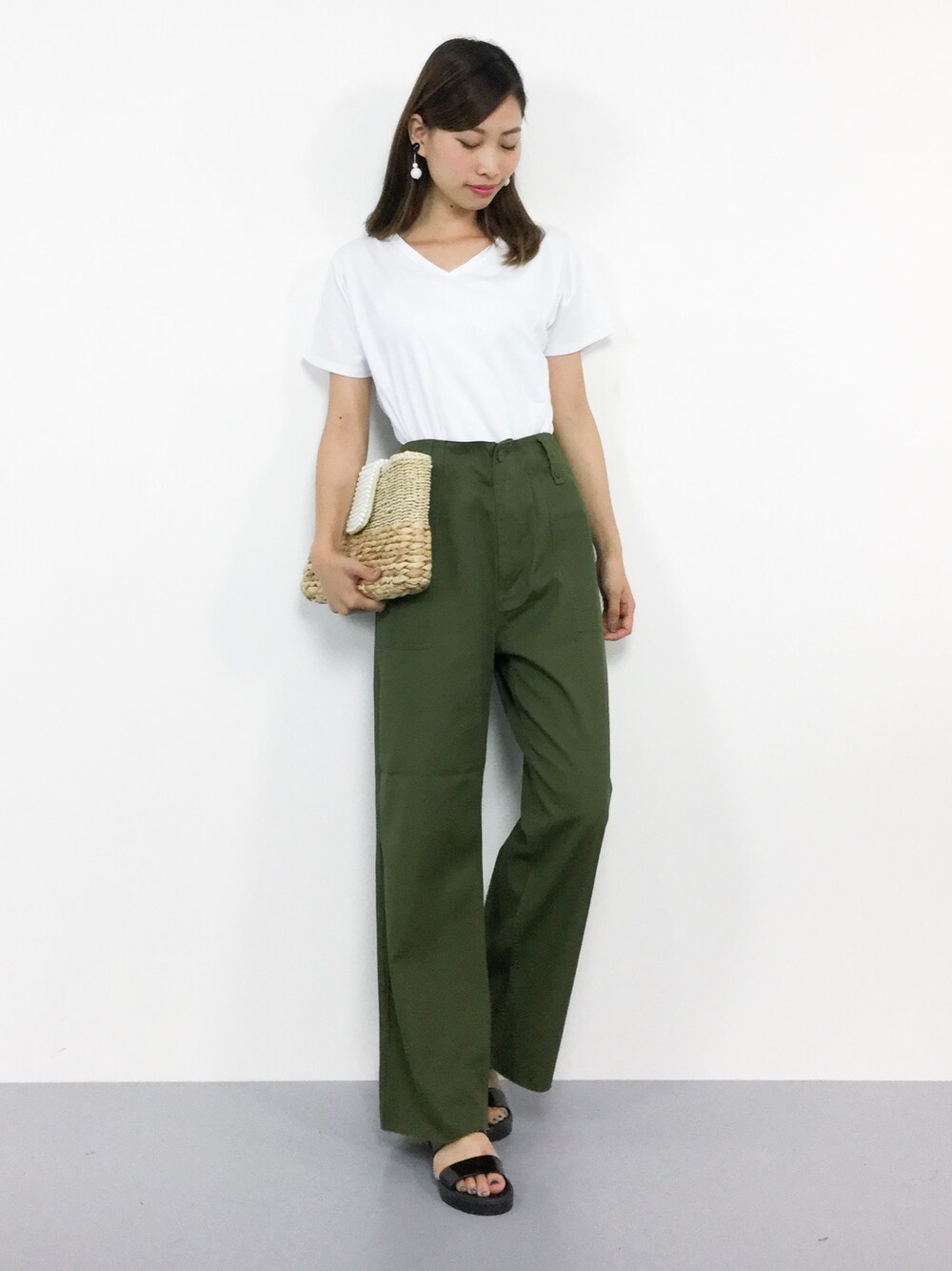 ホワイト系のTシャツ/カットソー、ベージュ系のクラッチバッグ、グリーン系のその他パンツを着用したレディースの夏コーディネートの1枚目の写真