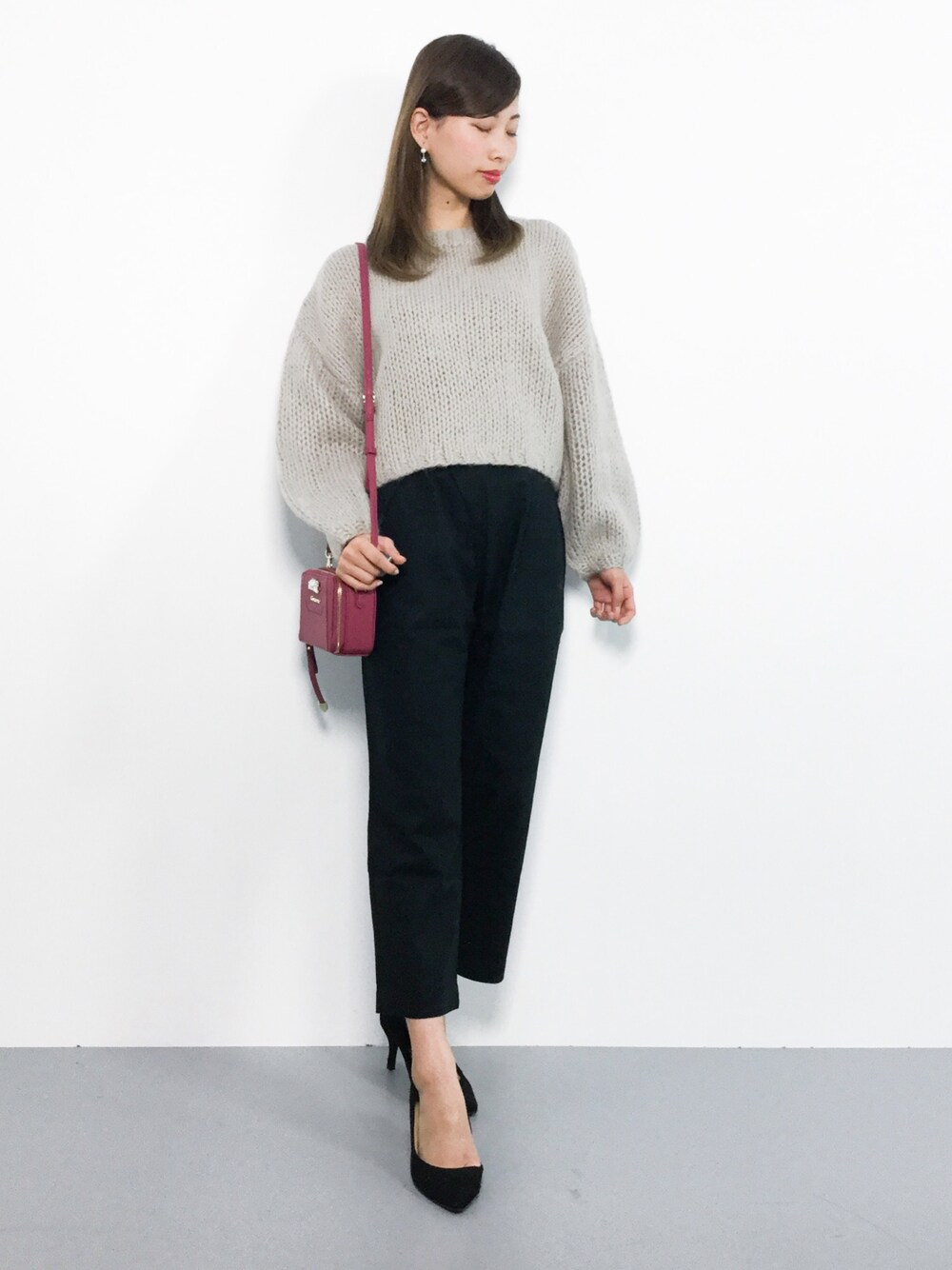ベージュ系のニット/セーター、ブラック系のその他パンツ、レッド系のショルダーバッグを着用したレディースの秋コーディネートの1枚目の写真