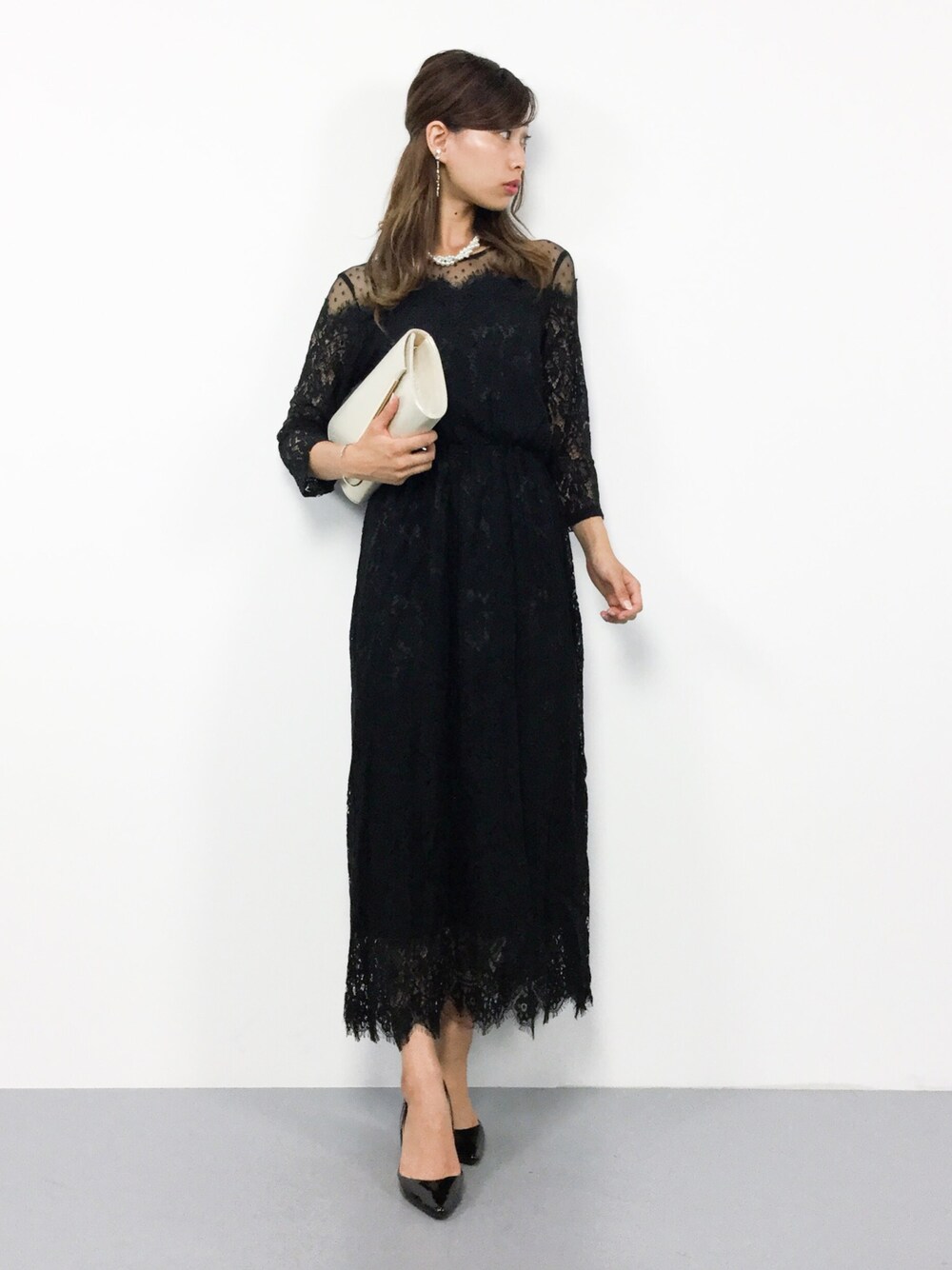 ブラック系のワンピース、ゴールド系のショルダーバッグを着用したレディースの夏コーディネートの1枚目の写真