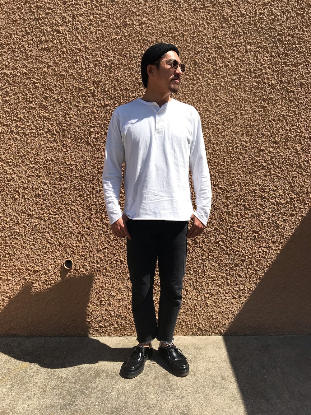 ホワイト系のTシャツ/カットソー、ブラック系のデニムパンツ、ブラック系のドレスシューズを着用したメンズの春コーディネートの1枚目の写真