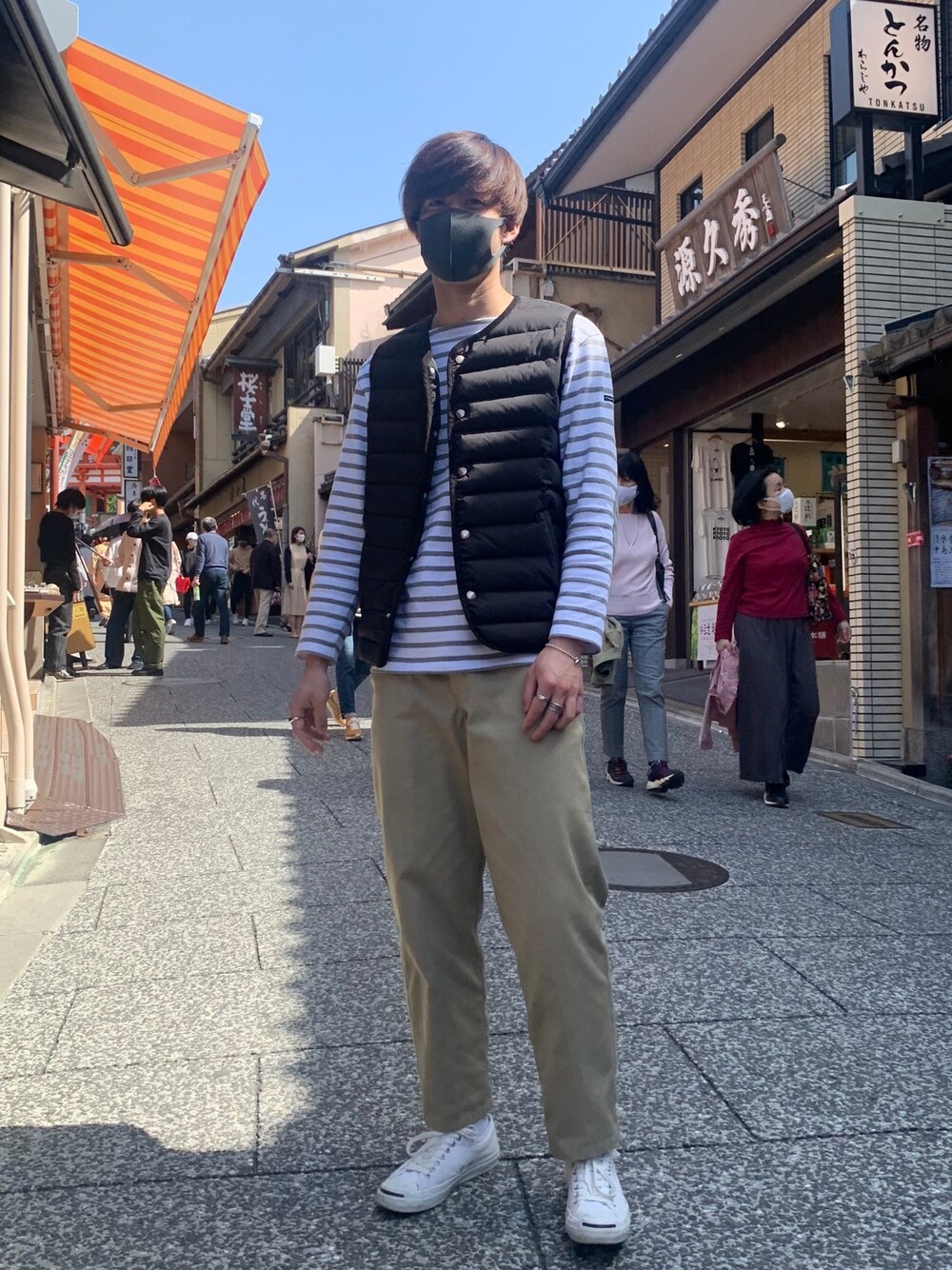 ホワイト系のスニーカー、ベージュ系のチノパンツ、ホワイト系のTシャツ/カットソーを着用したメンズの春コーディネートの1枚目の写真