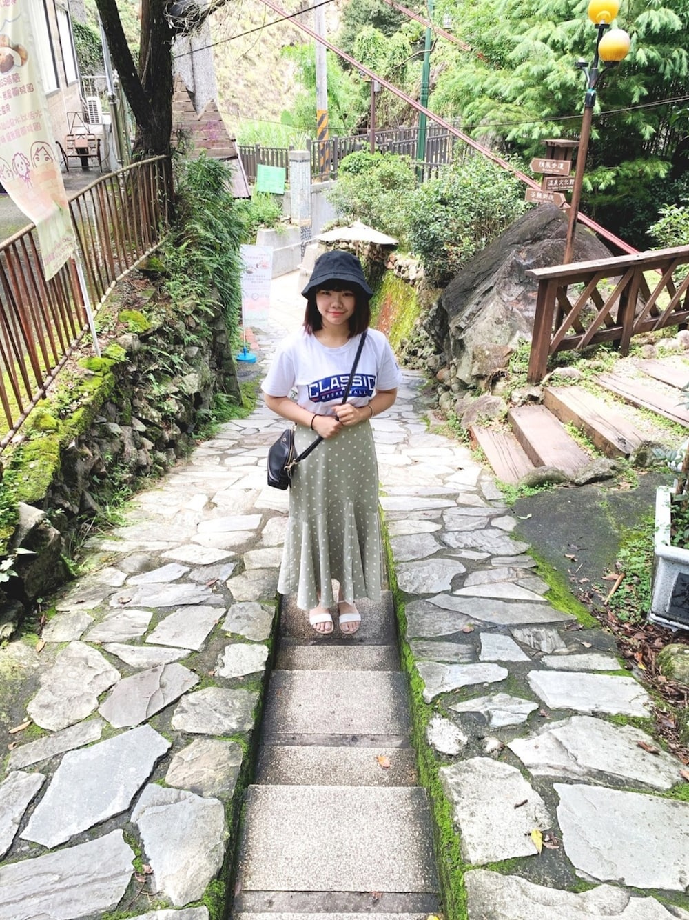 ブラック系のショルダーバッグを着用したレディースの夏コーディネートの1枚目の写真