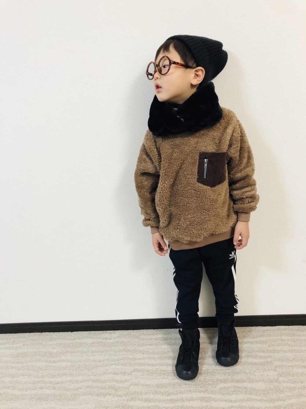 ブラウン系のスウェット、ブルー系のパンツ、ブラック系のスニーカーを着用したキッズの冬コーディネートの1枚目の写真