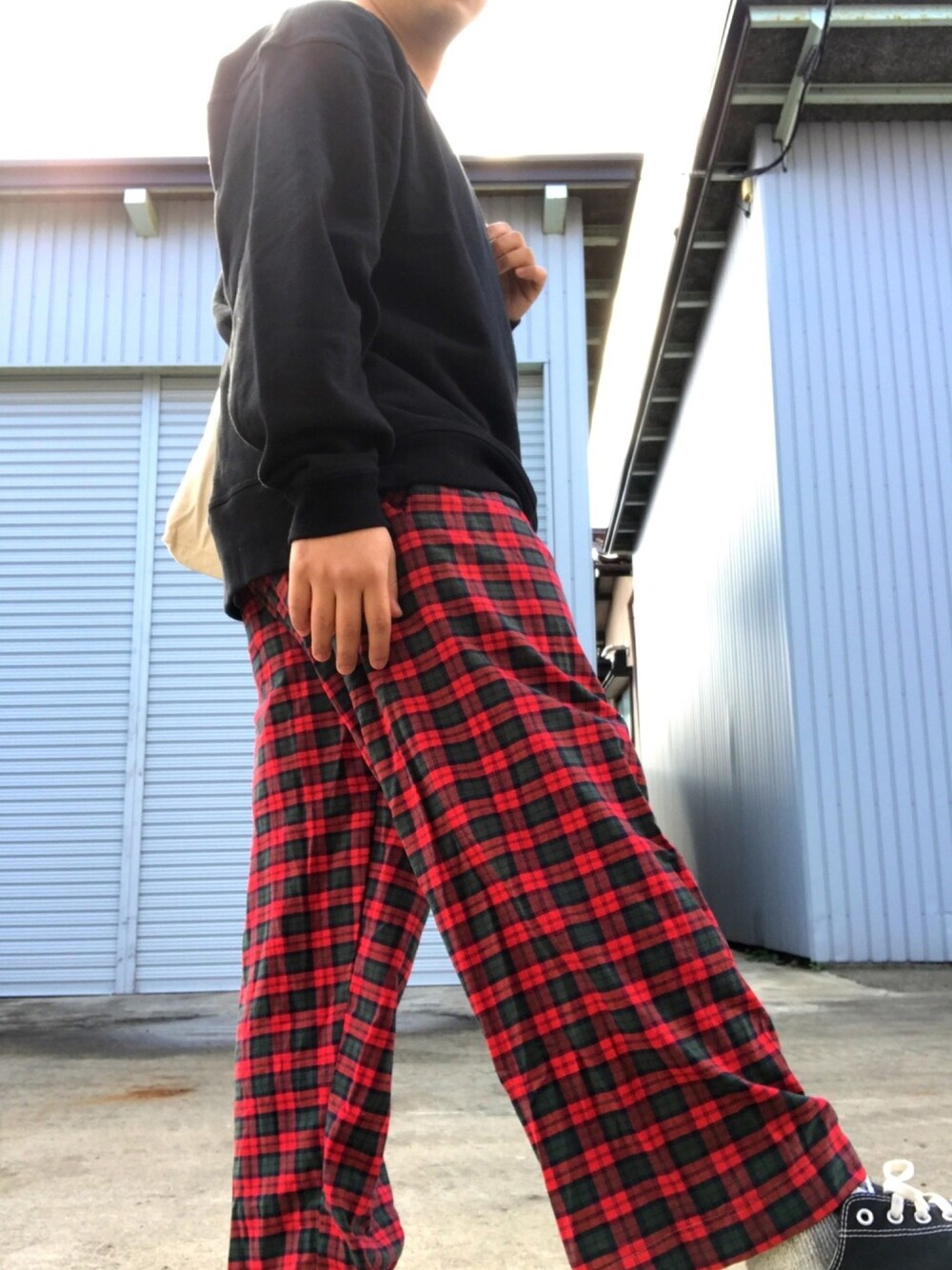 ブラック系のスウェット、レッド系のパンツ、ブラック系のスニーカーを着用したメンズの秋コーディネートの1枚目の写真