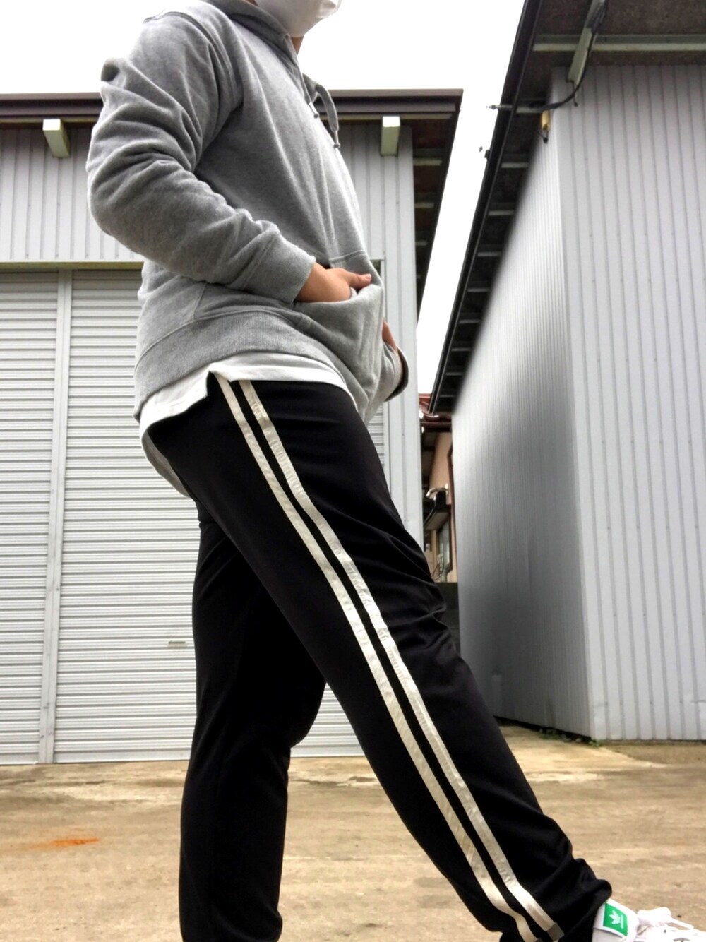 グレー系のパーカー、ブラック系のその他パンツ、グリーン系のスニーカーを着用したメンズの秋コーディネートの1枚目の写真