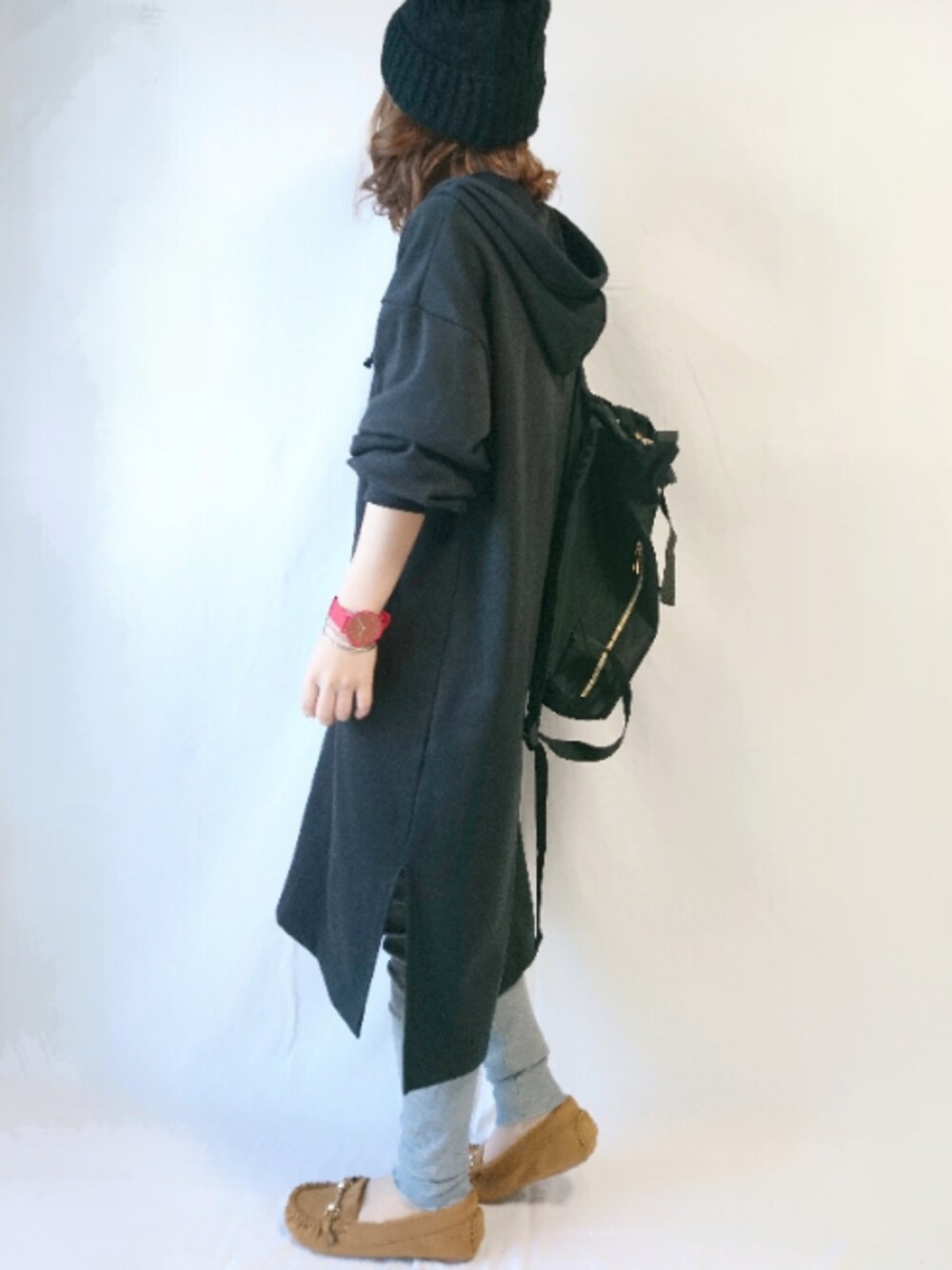 ブラック系のワンピース、ブラック系のバックパック/リュック、イエロー系のシューズを着用したレディースの冬コーディネートの1枚目の写真