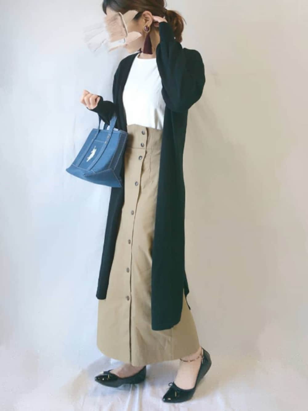 ブラック系のカーディガン/ボレロ、ベージュ系のワンピース、ブルー系のトートバッグを着用したレディースの春コーディネートの1枚目の写真