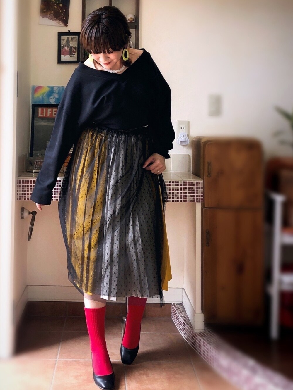 ブラック系のスウェット、パープル系のスカート、ブラック系のスカートを着用したレディースの春コーディネートの1枚目の写真