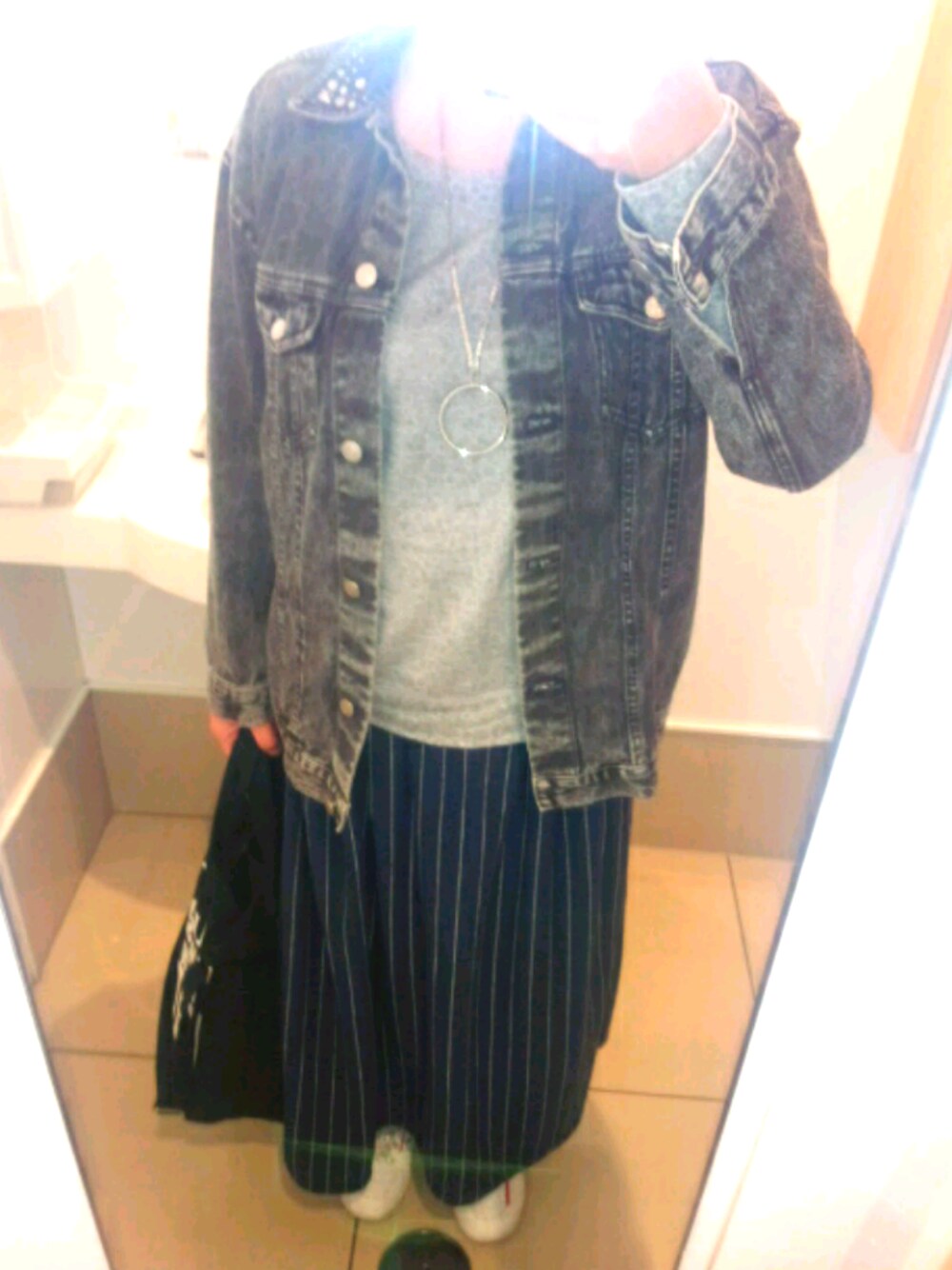 ブラック系のデニムジャケット、ブラック系のトートバッグを着用したレディースの春コーディネートの1枚目の写真