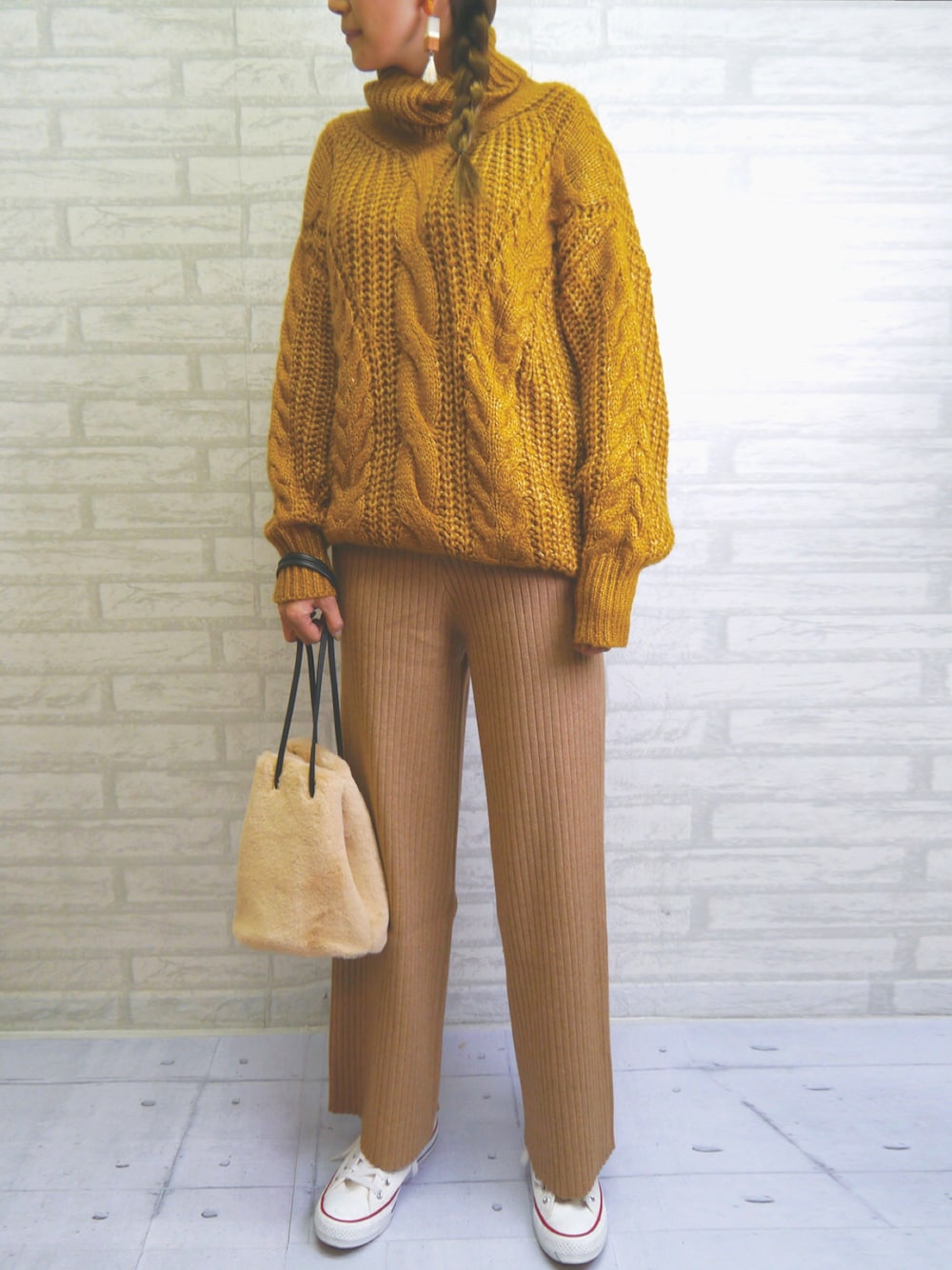 ベージュ系のその他パンツ、イエロー系のニット/セーター、ベージュ系のハンドバッグを着用したレディースの冬コーディネートの1枚目の写真