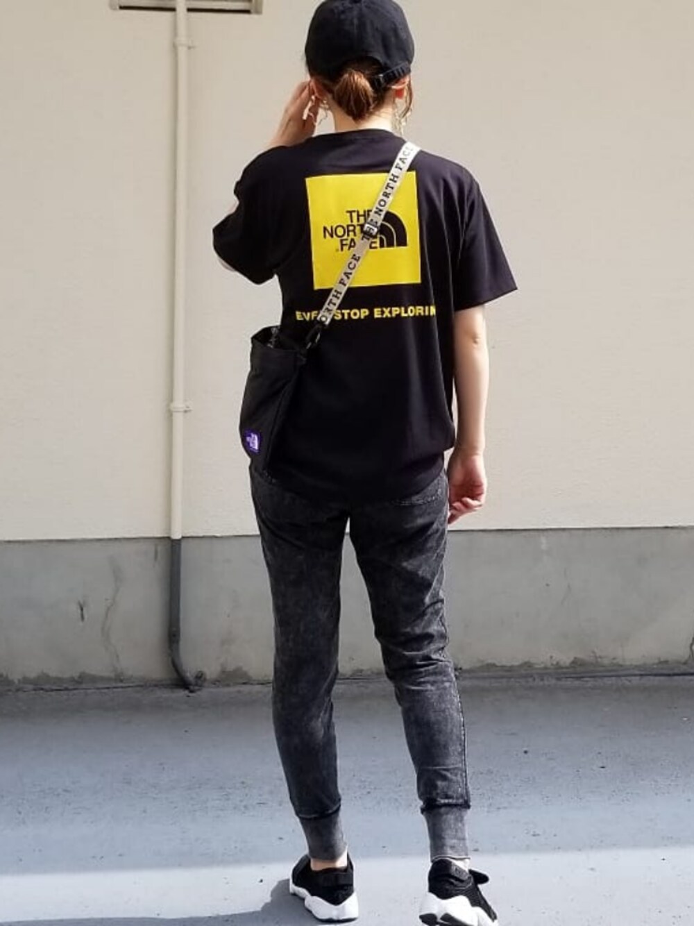 ブラック系のショルダーバッグ、ブラック系のTシャツ/カットソー、ブラック系のスニーカーを着用したレディースの夏コーディネートの1枚目の写真