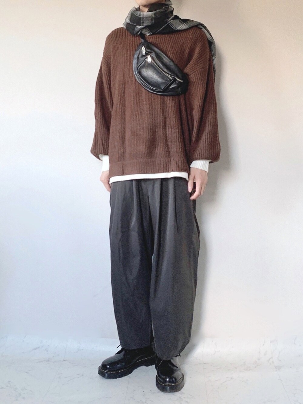 ブラウン系のニット/セーター、ブラック系のボディバッグ/ウエストポーチ、グレー系のその他パンツを着用したメンズの秋コーディネートの1枚目の写真