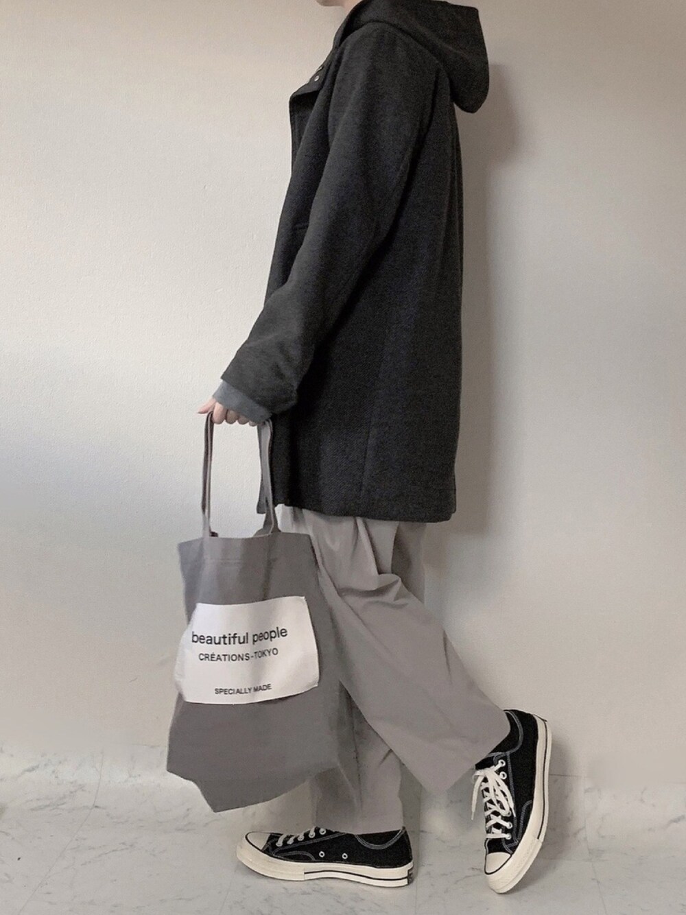 グレー系のモッズコート、ベージュ系のその他パンツ、グレー系のトートバッグを着用したメンズの冬コーディネートの1枚目の写真