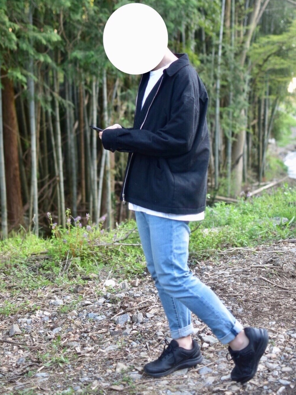 ブルー系のデニムパンツ、ブラック系のブルゾン、ブラック系のスニーカーを着用したメンズの春コーディネートの1枚目の写真