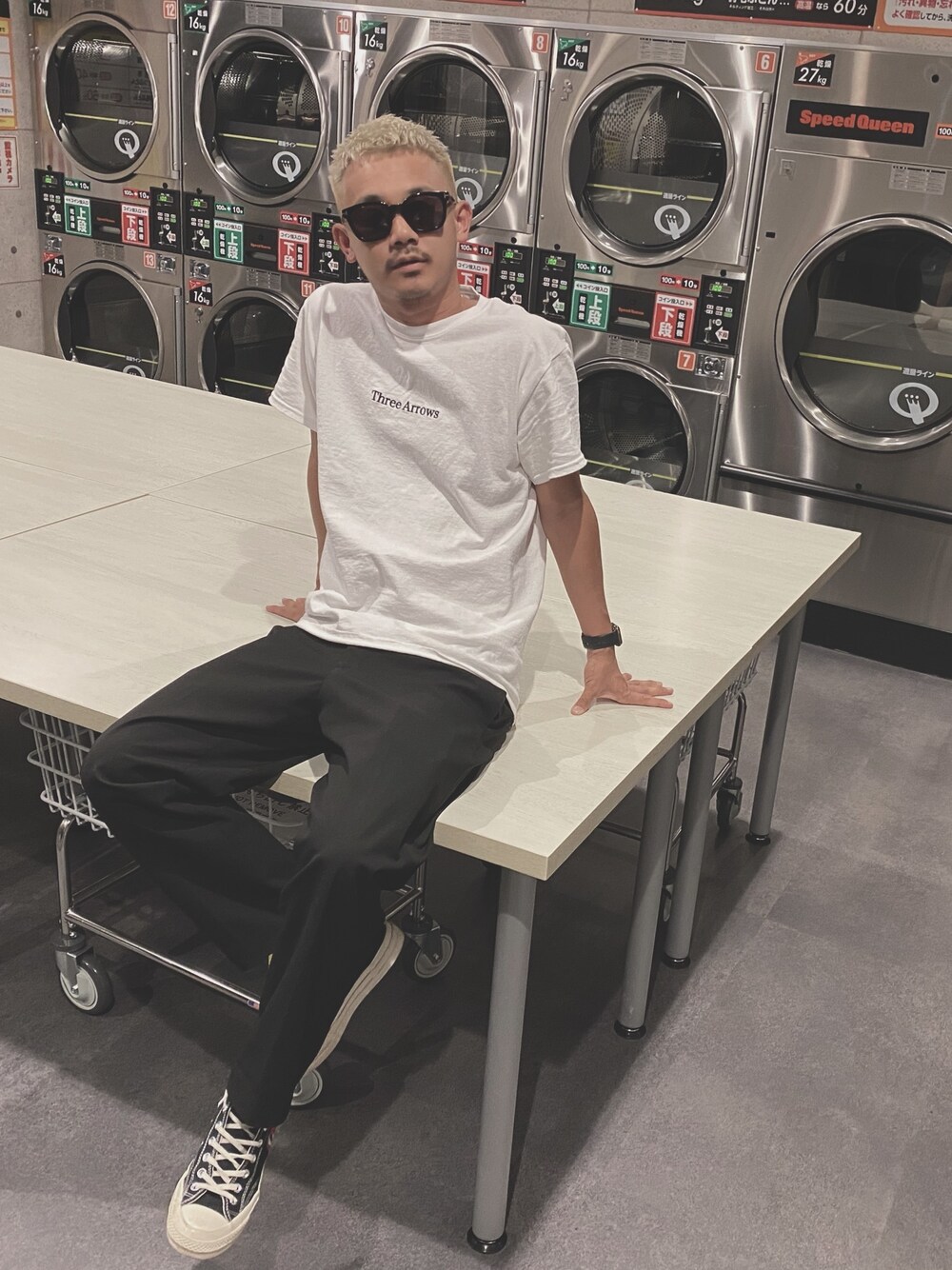 ホワイト系のTシャツ/カットソー、ブラック系のスラックス、ブラック系のスニーカーを着用したメンズの春コーディネートの1枚目の写真