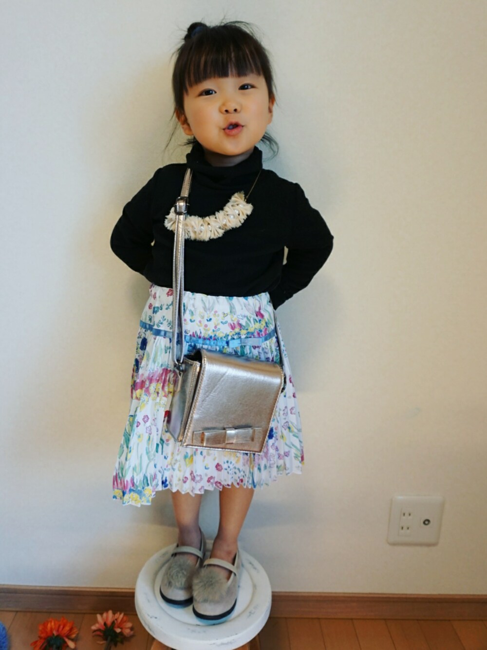 ブルー系のスカート、ブラック系のTシャツ/カットソー、シルバー系のショルダーバッグを着用したキッズの冬コーディネートの1枚目の写真