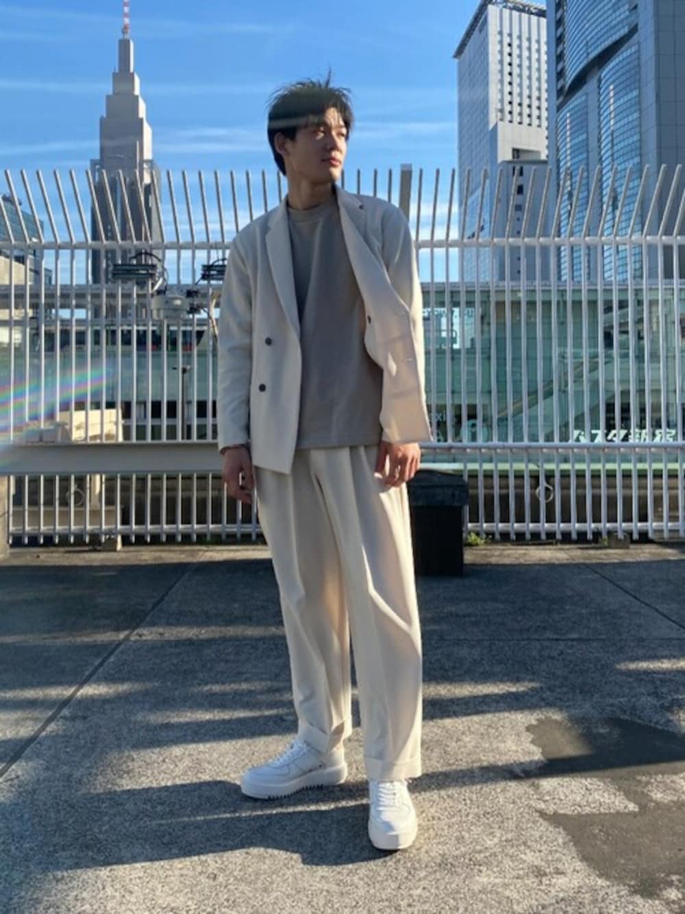 ホワイト系のテーラードジャケット、ベージュ系のスラックス、ベージュ系のスウェットを着用したメンズの冬コーディネートの1枚目の写真