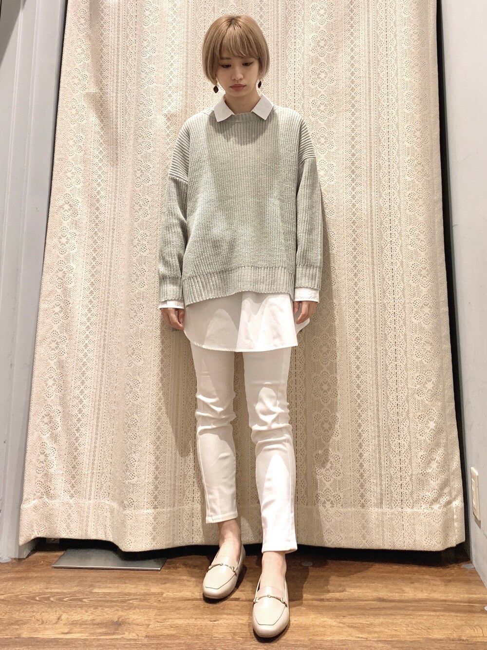 グリーン系のニット/セーター、ホワイト系のパンツ、ベージュ系のローファーを着用したレディースの春コーディネートの1枚目の写真