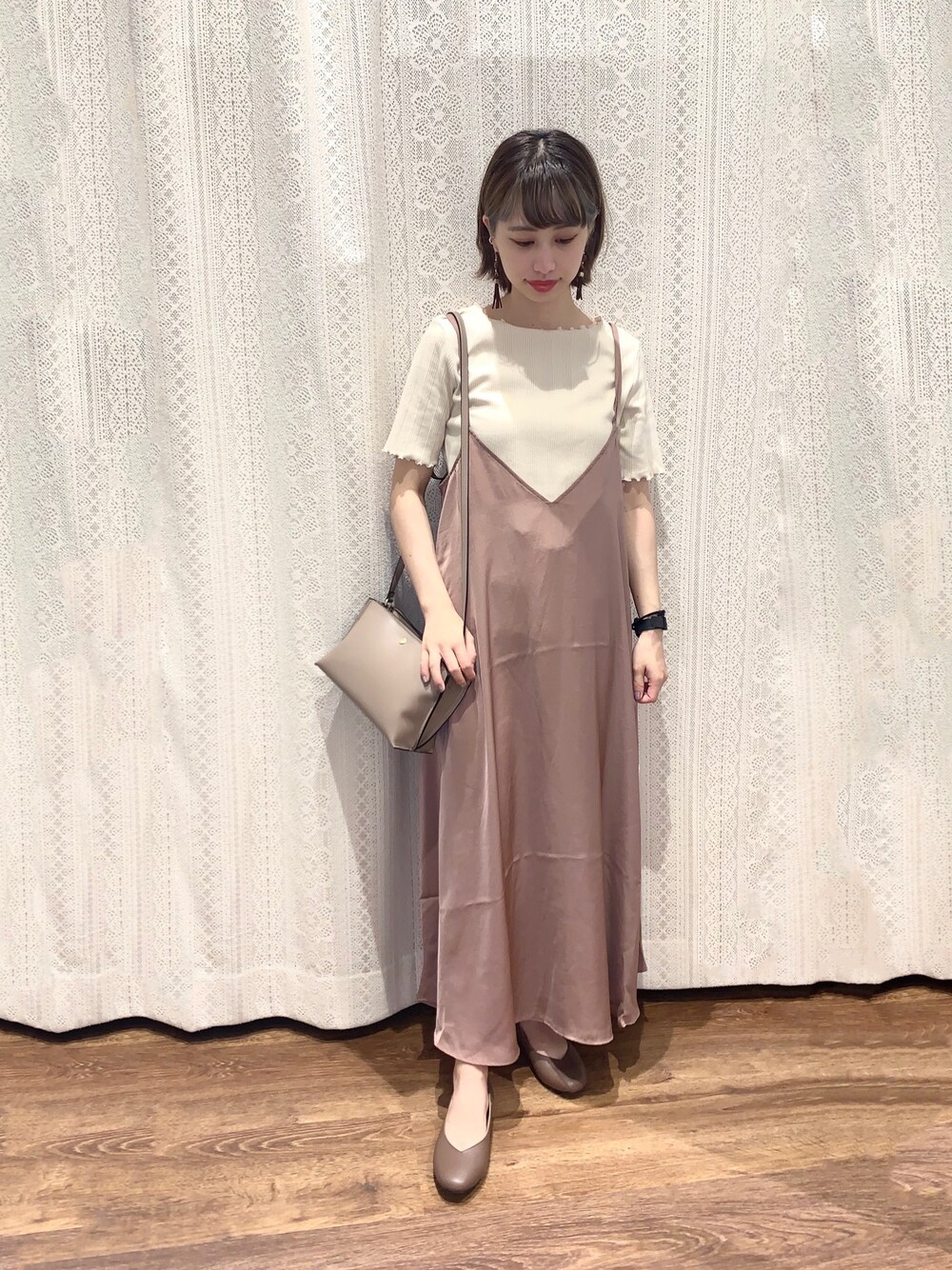 ピンク系のショルダーバッグ、ピンク系のワンピース、ブラウン系のパンプスを着用したレディースの夏コーディネートの1枚目の写真
