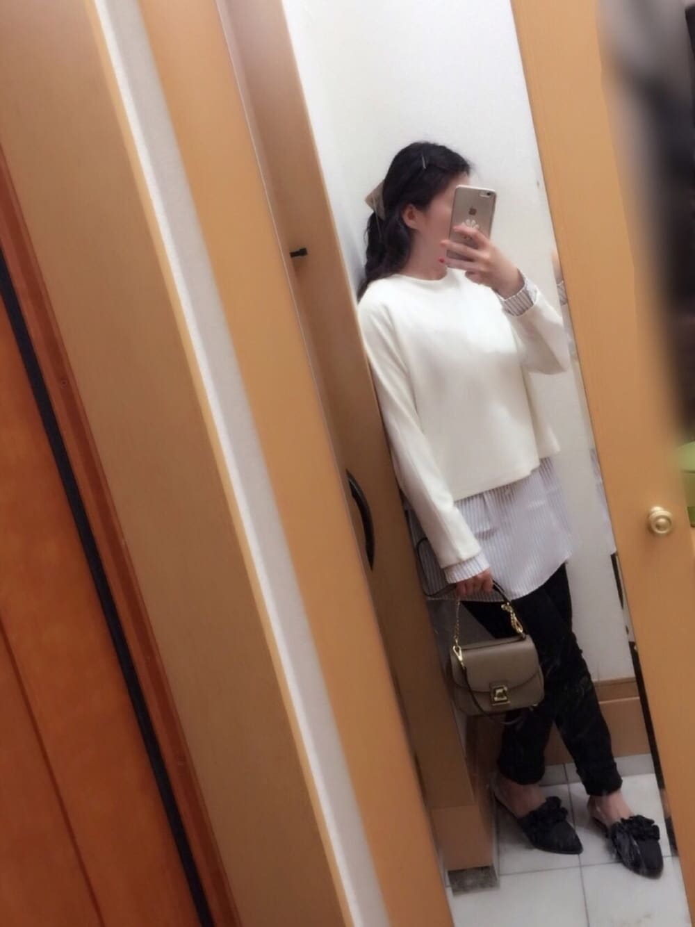 ホワイト系のトップス、ベージュ系のショルダーバッグ、ブラック系のパンツを着用したレディースの春コーディネートの1枚目の写真