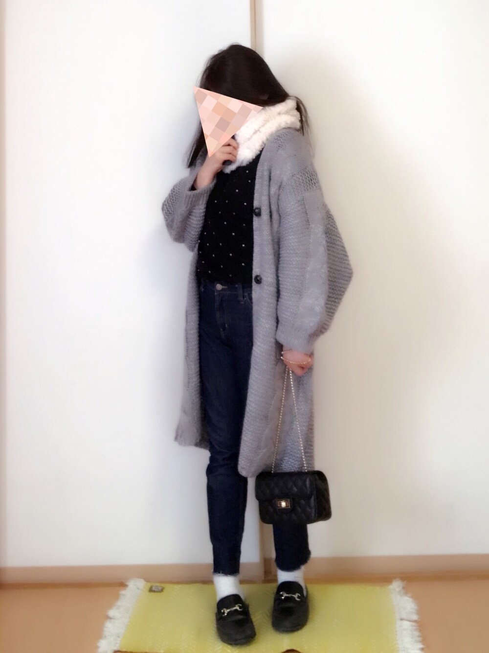 グレー系のカーディガン/ボレロ、ブラック系のショルダーバッグ、ブルー系のデニムパンツを着用したレディースの冬コーディネートの1枚目の写真