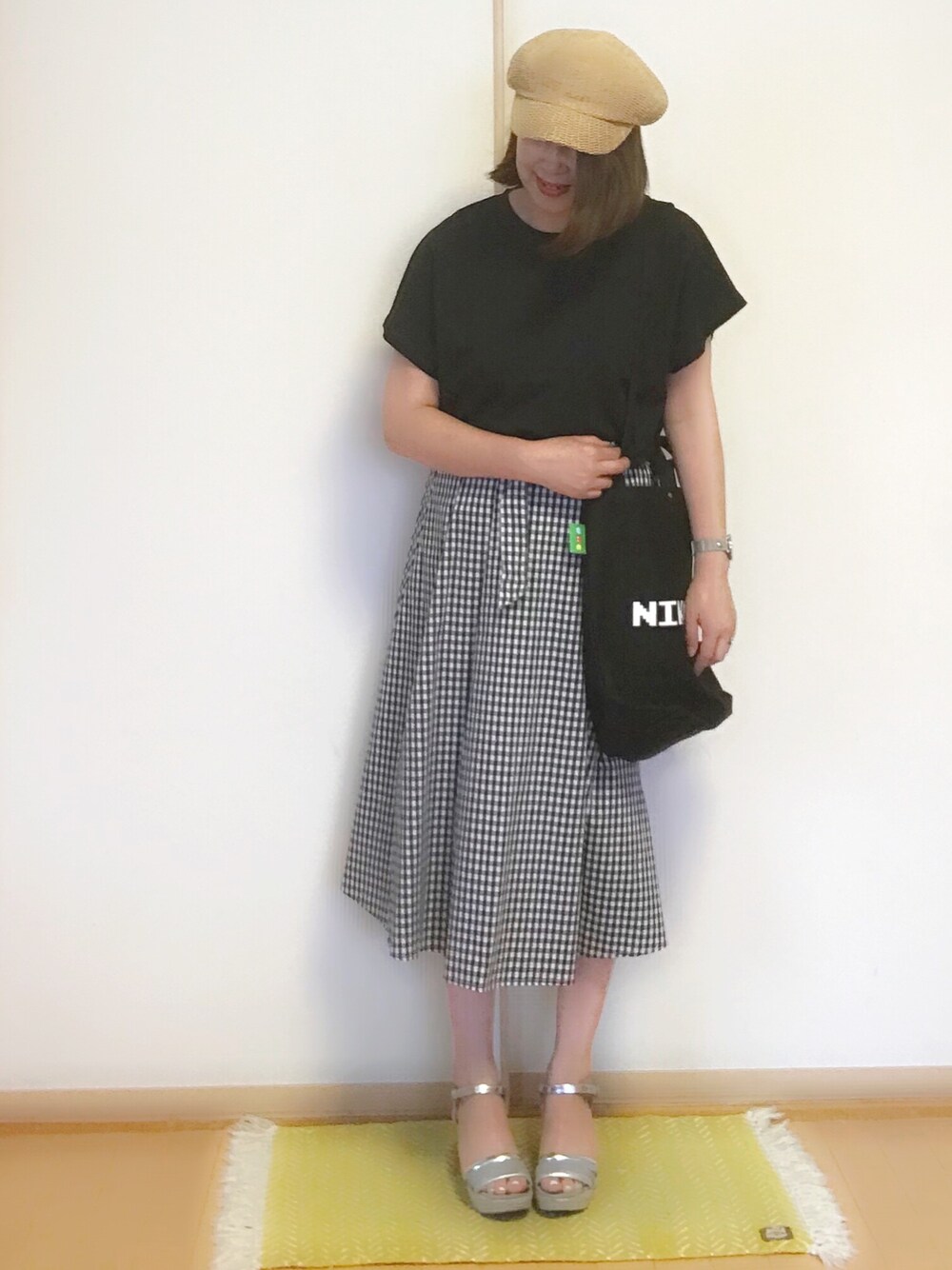 ブラック系のTシャツ/カットソー、ブラック系のスカート、ブラック系のトートバッグを着用したレディースの夏コーディネートの1枚目の写真