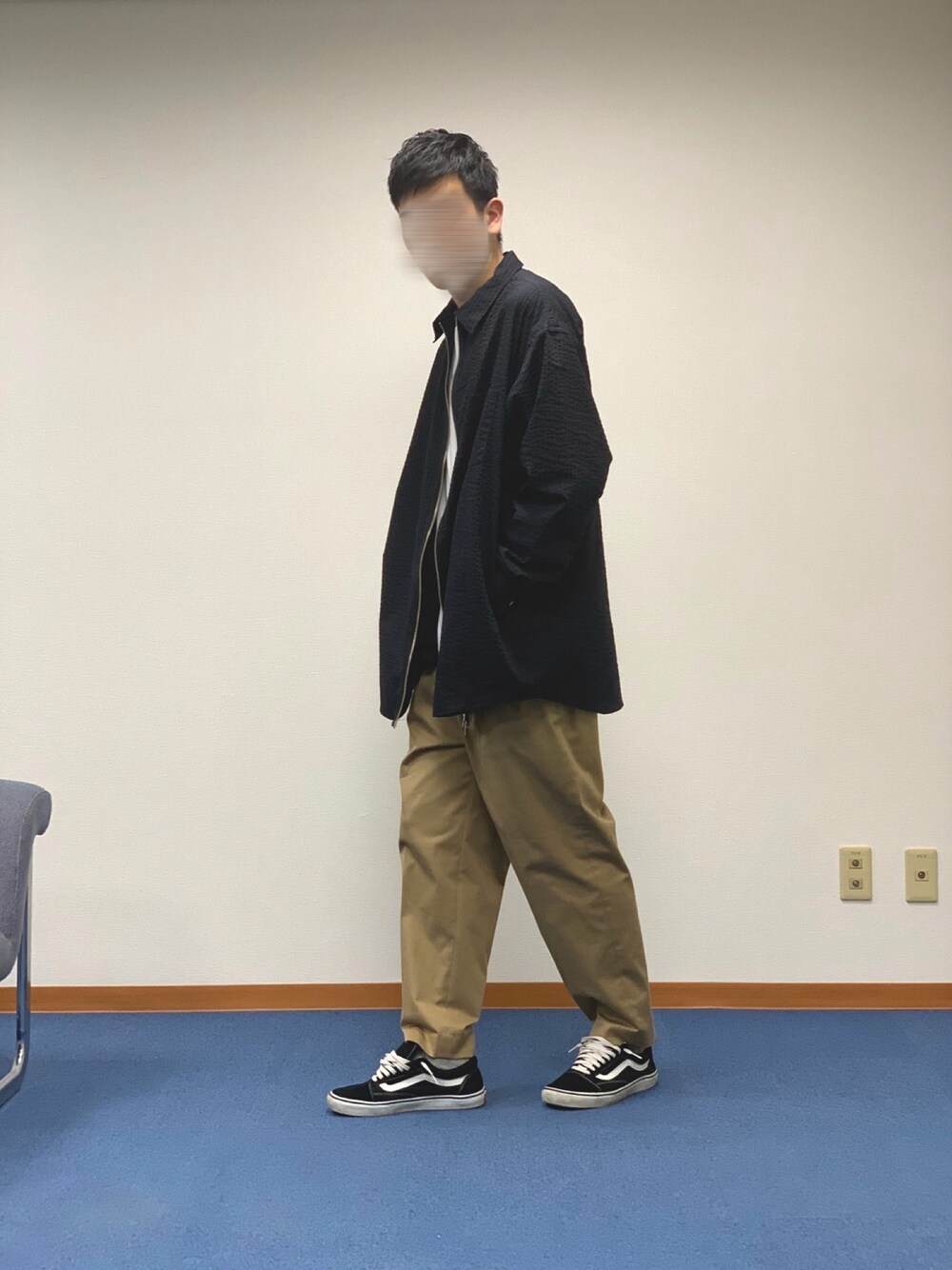 ブラック系のジャケット/アウター、ベージュ系のパンツ、ブラック系のスニーカーを着用したメンズの春コーディネートの1枚目の写真