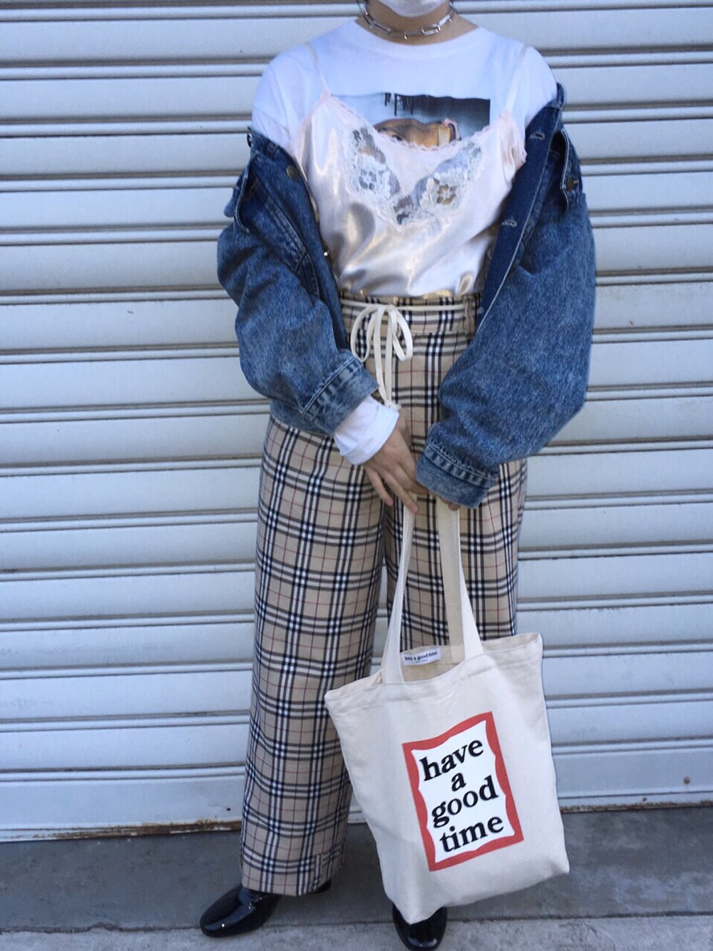 ベージュ系のトートバッグ、ベージュ系のパンツ、ブラック系のブーツを着用したレディースの春コーディネートの1枚目の写真