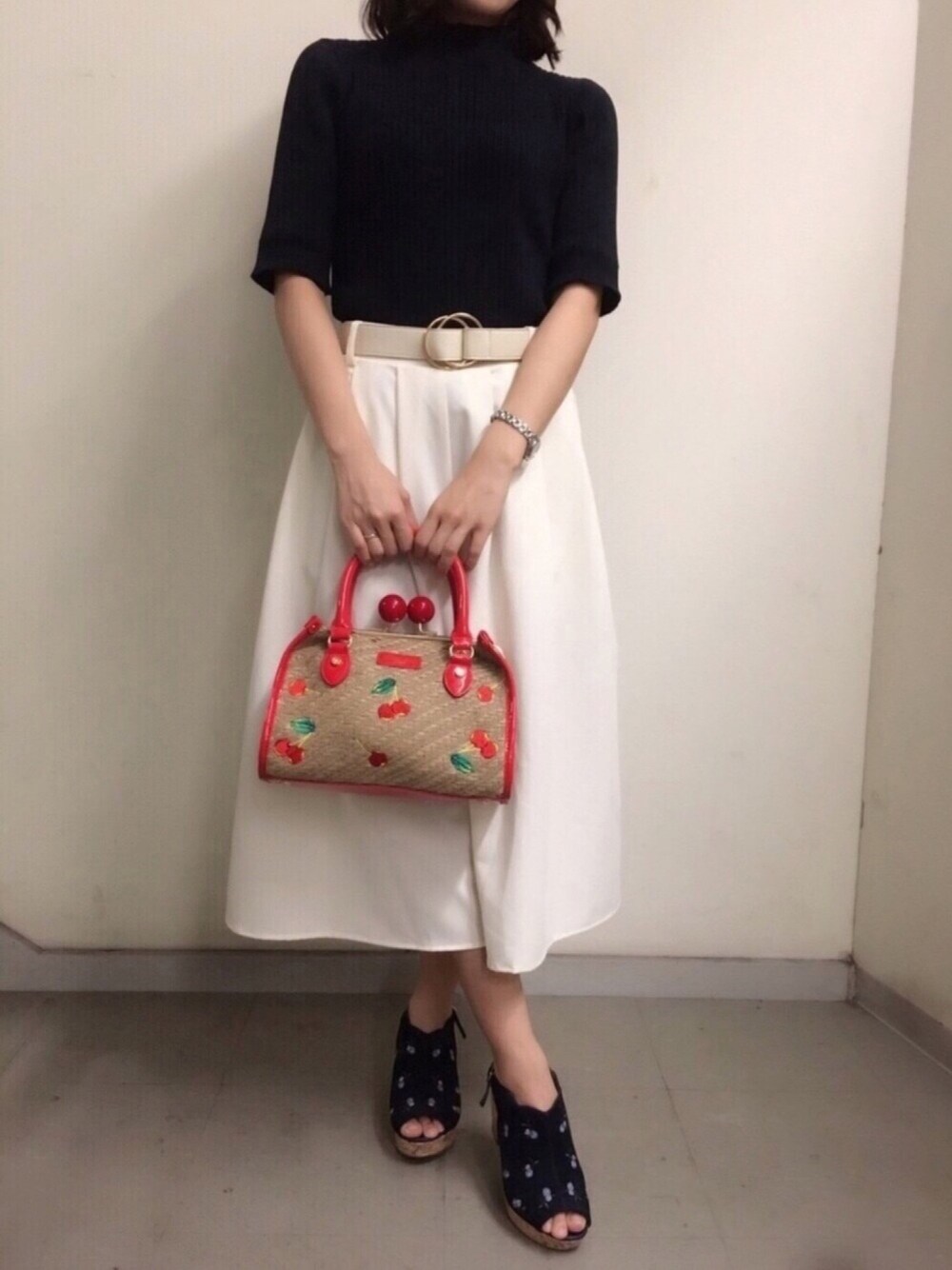 ブルー系のニット/セーター、レッド系のハンドバッグ、ブルー系のサンダルを着用したレディースの春コーディネートの1枚目の写真