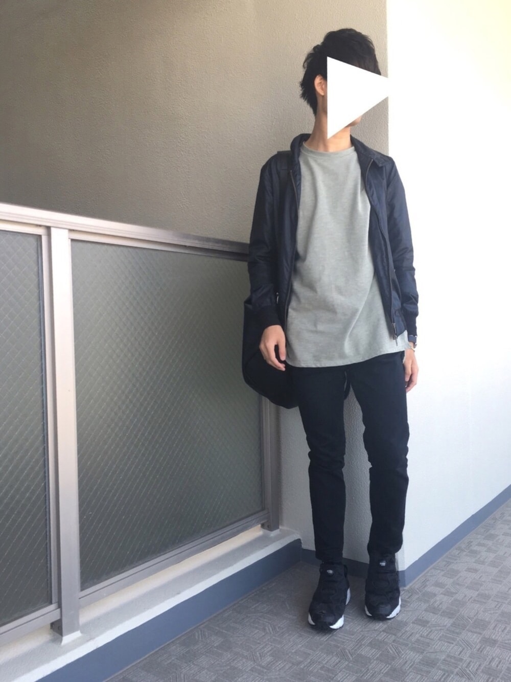 ブラック系のナイロンジャケット、グリーン系のTシャツ/カットソー、ブラック系のチノパンツを着用したメンズの春コーディネートの1枚目の写真