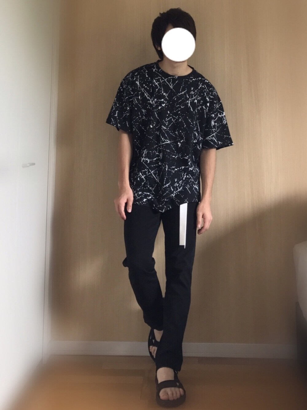 ブラック系のTシャツ/カットソー、ブラック系のデニムパンツ、ブラック系のサンダルを着用したメンズの夏コーディネートの1枚目の写真