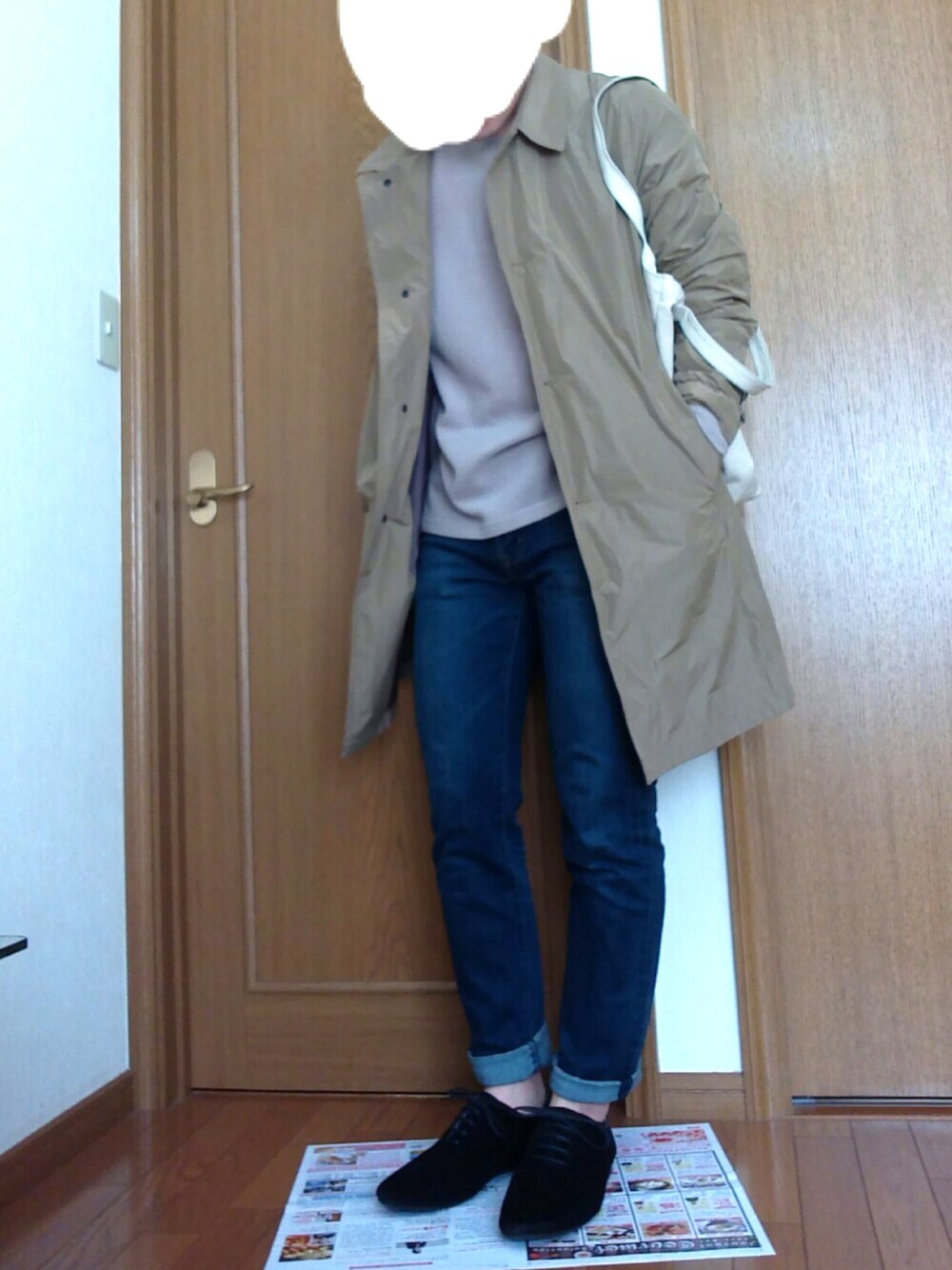 ブルー系のデニムパンツ、ベージュ系のステンカラーコート、ベージュ系のニット/セーターを着用したメンズの春コーディネートの1枚目の写真