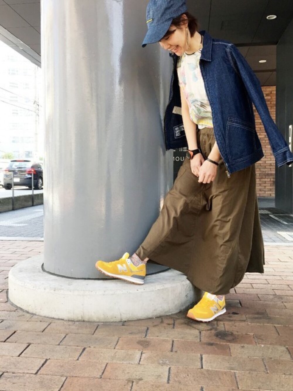 イエロー系のスニーカー、グリーン系のスカート、ホワイト系のTシャツ/カットソーを着用したレディースの春コーディネートの1枚目の写真