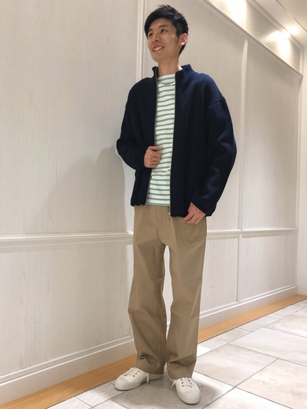 グリーン系のTシャツ/カットソー、ブルー系のジャケット/アウター、ベージュ系のチノパンツを着用したメンズの冬コーディネートの1枚目の写真