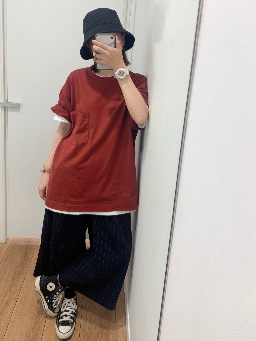 レッド系のTシャツ/カットソー、ホワイト系のスニーカー、ブラック系の帽子を着用したレディースの夏コーディネートの1枚目の写真