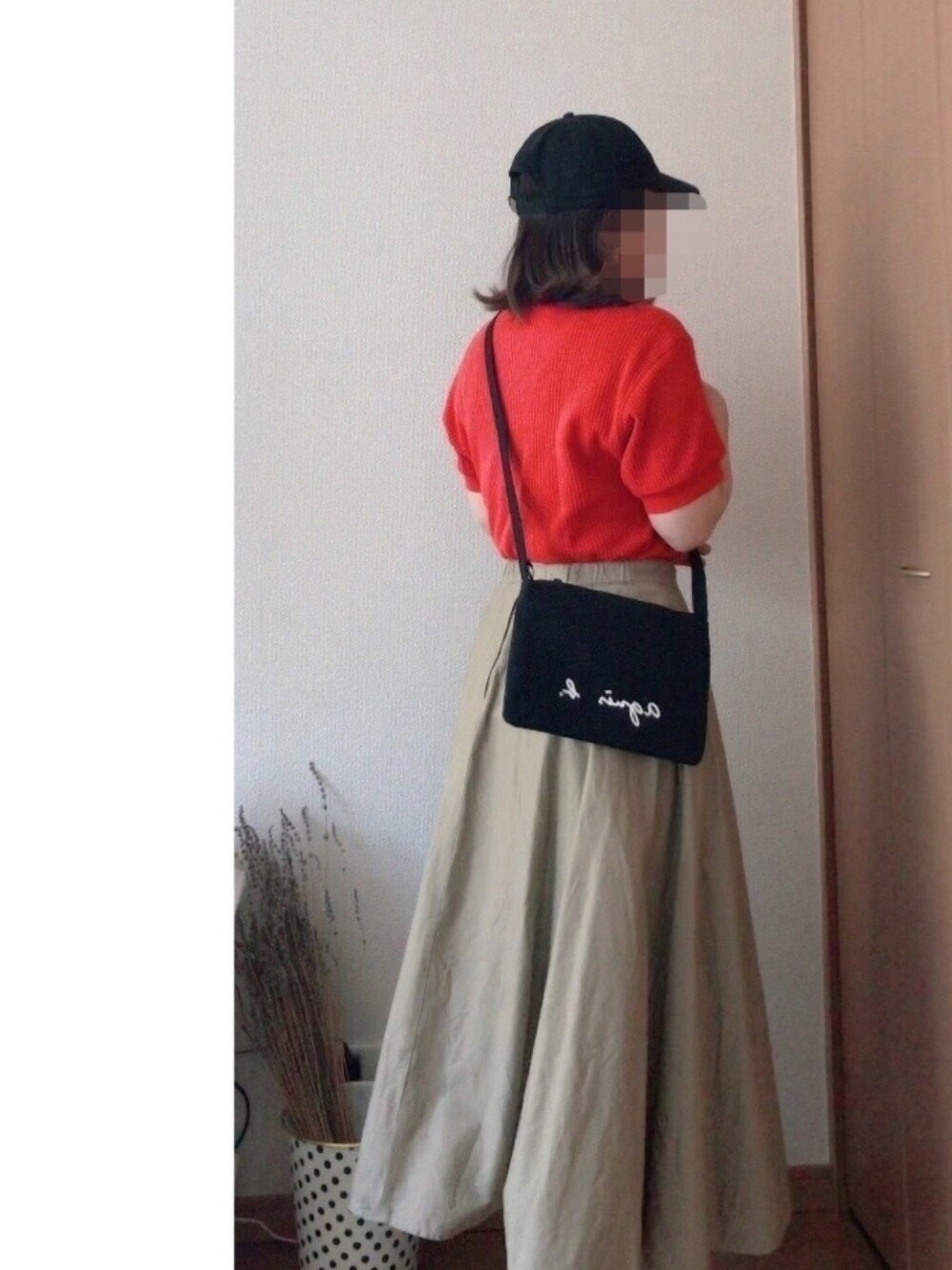 レッド系のTシャツ/カットソー、ブラック系のショルダーバッグ、ベージュ系のスカートを着用したレディースの春コーディネートの1枚目の写真