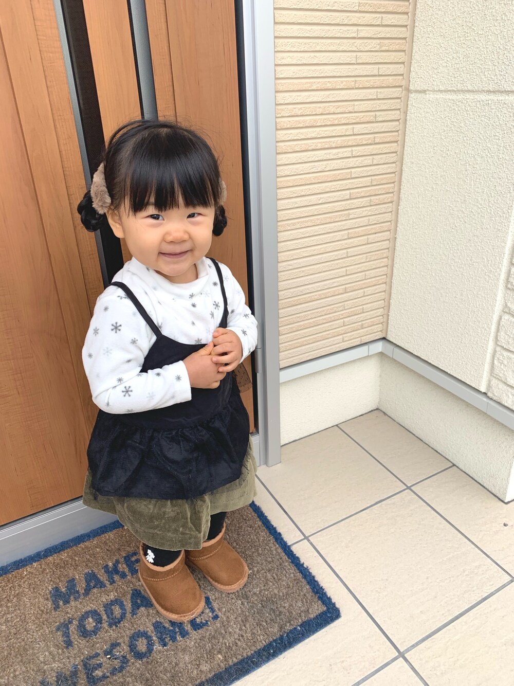 ホワイト系のトップス、グレー系のTシャツ/カットソー、グリーン系のスカートを着用したキッズの冬コーディネートの1枚目の写真