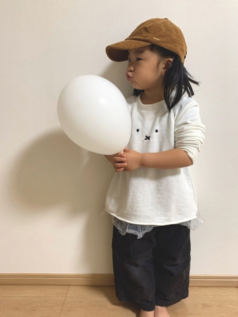 ホワイト系のトップス、ブラック系のその他パンツ、ブラウン系のキャップを着用したキッズの春コーディネートの1枚目の写真